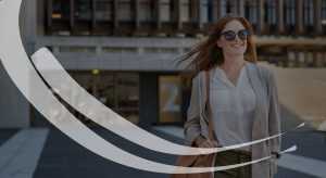woman wearing sunglasses holds bag