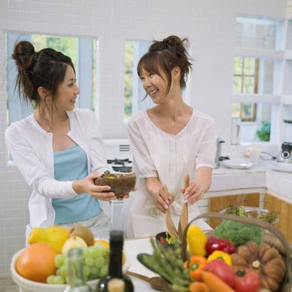 two healthy woman eating veggies